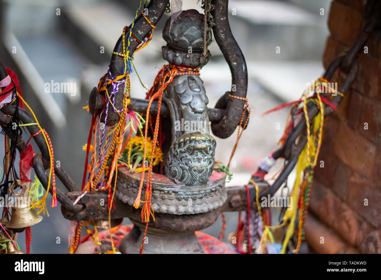 Sacred thread tied around bronze statue in Pokhara lake temple in Nepal ...