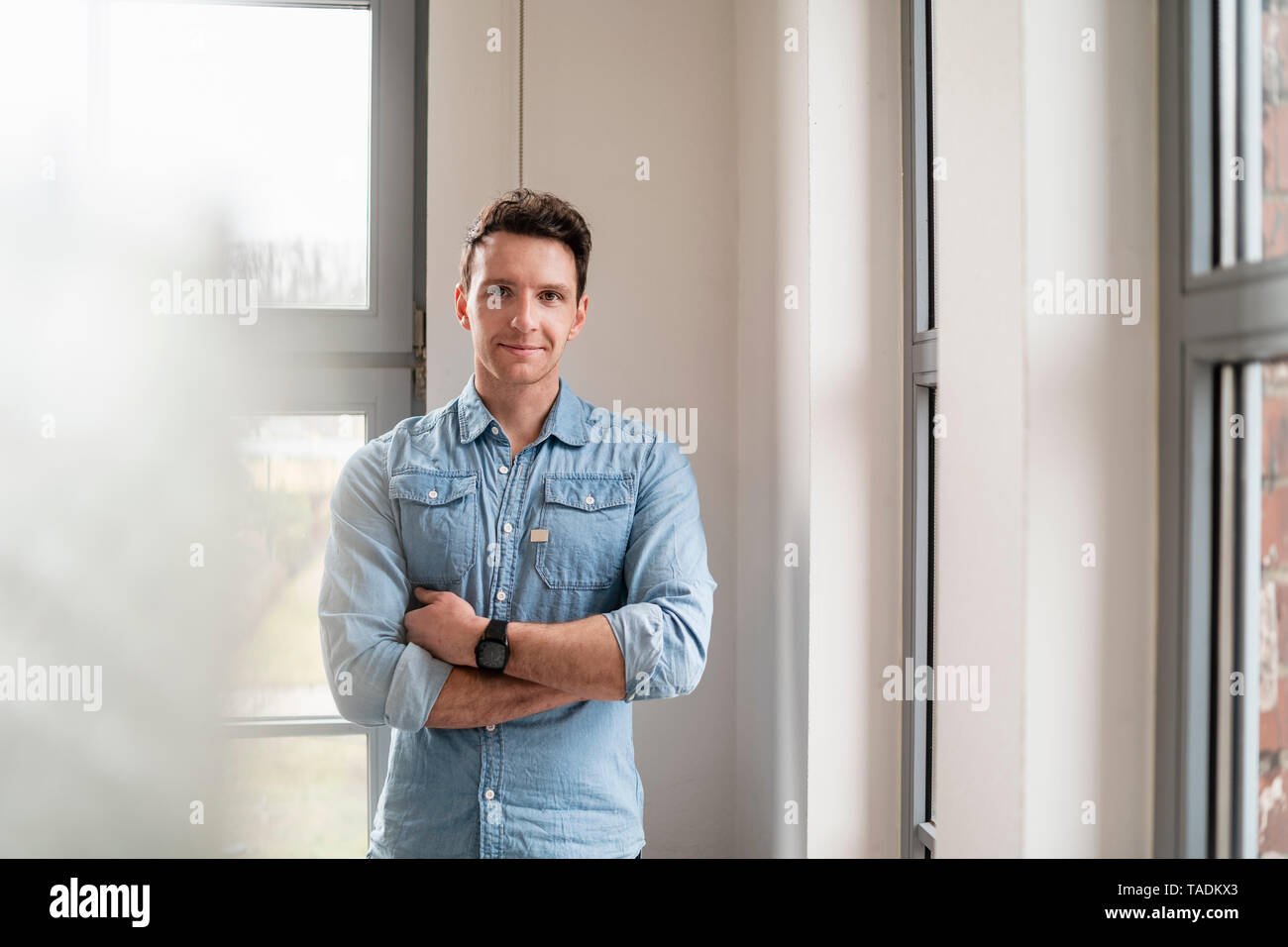 Portrait of confident businessman at the window in office Stock Photo