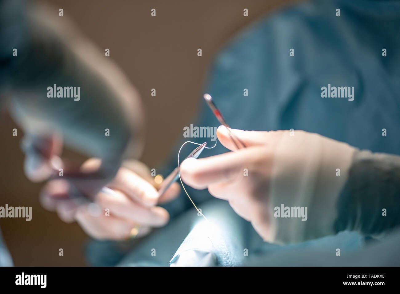 Doctors sewing a wound from an ankle operation in hospital Stock Photo