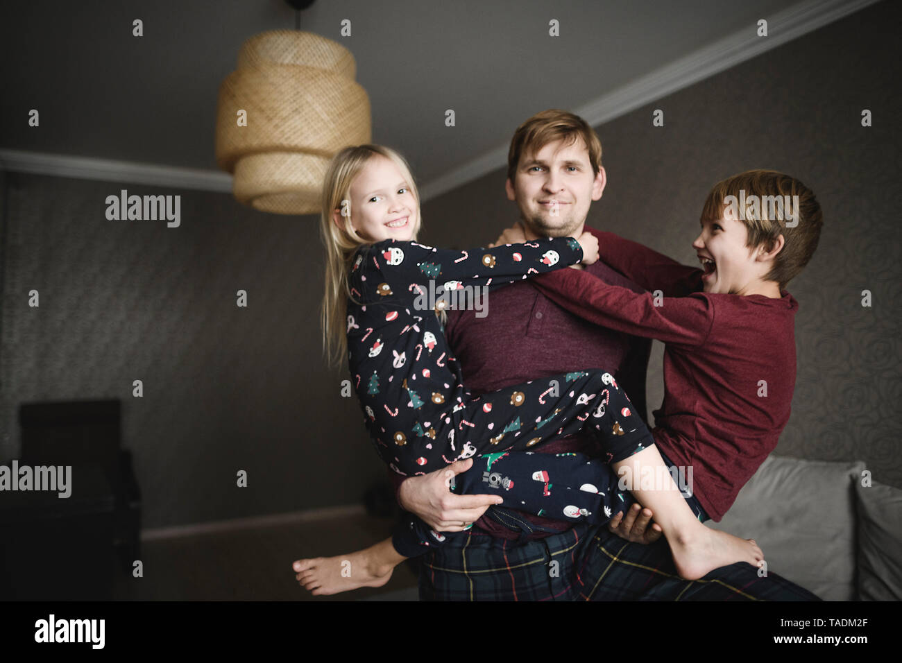 Portrait of father playing with his children at home Stock Photo