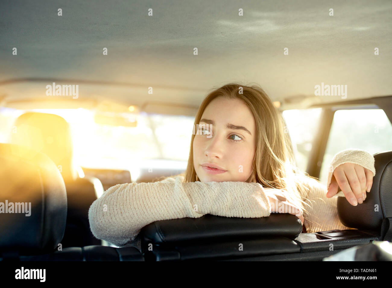 Young woman sitting on back seat in car looking sideways Stock Photo