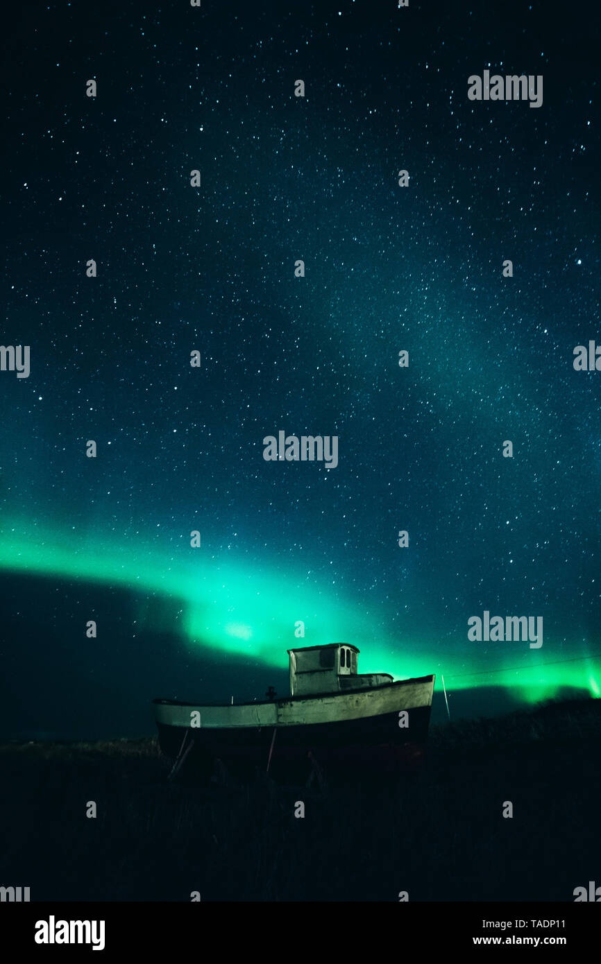 Norway, Lofoten Islands, Eggum, fishing boat under starry sky and Nothern lights Stock Photo