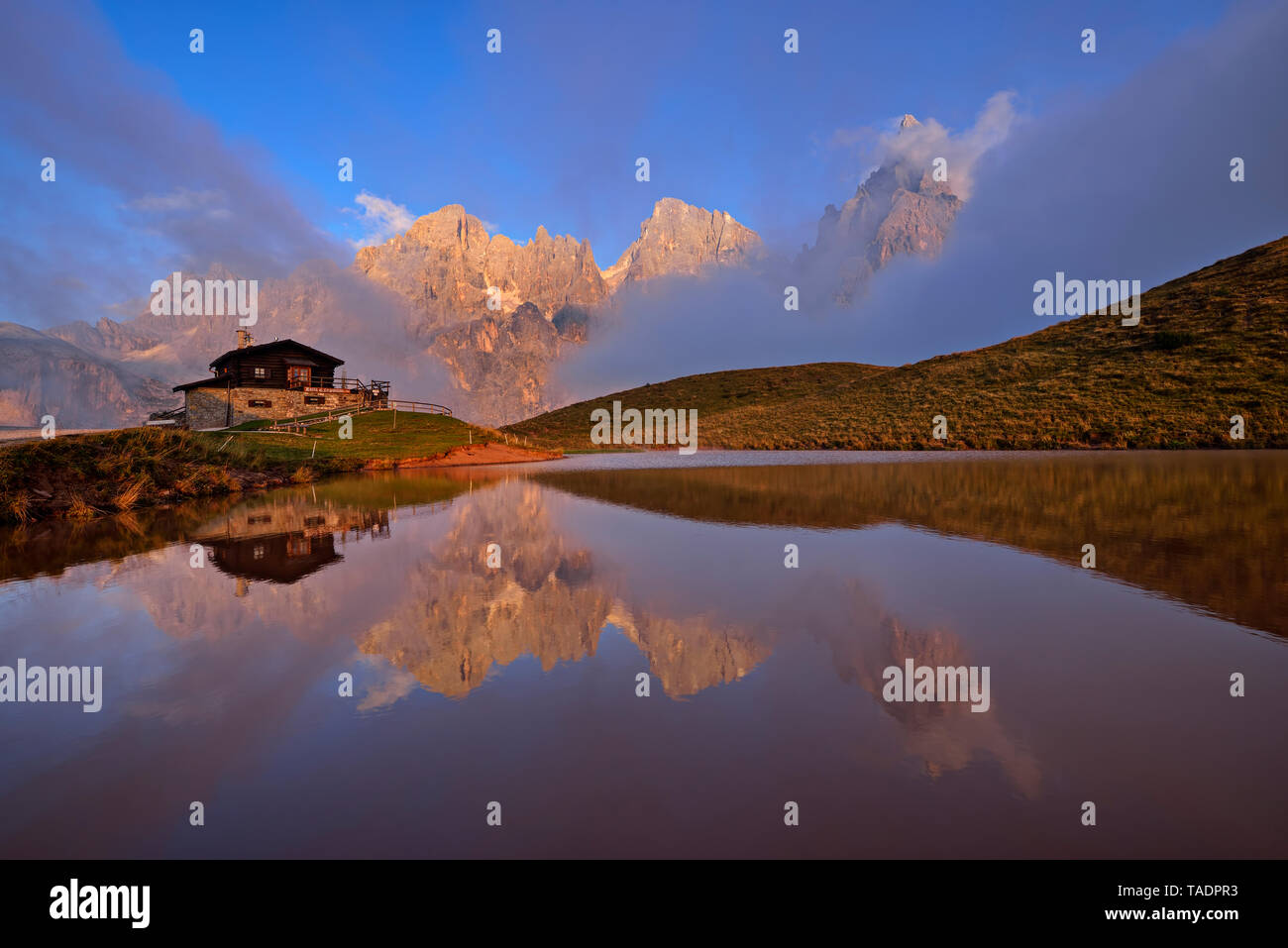 Italy, the mountain group with the mountain Pale di San Martino with Cimon della Pala reflecting in small lake at sunset, Rifugio Baita Giovanni Segantini Stock Photo