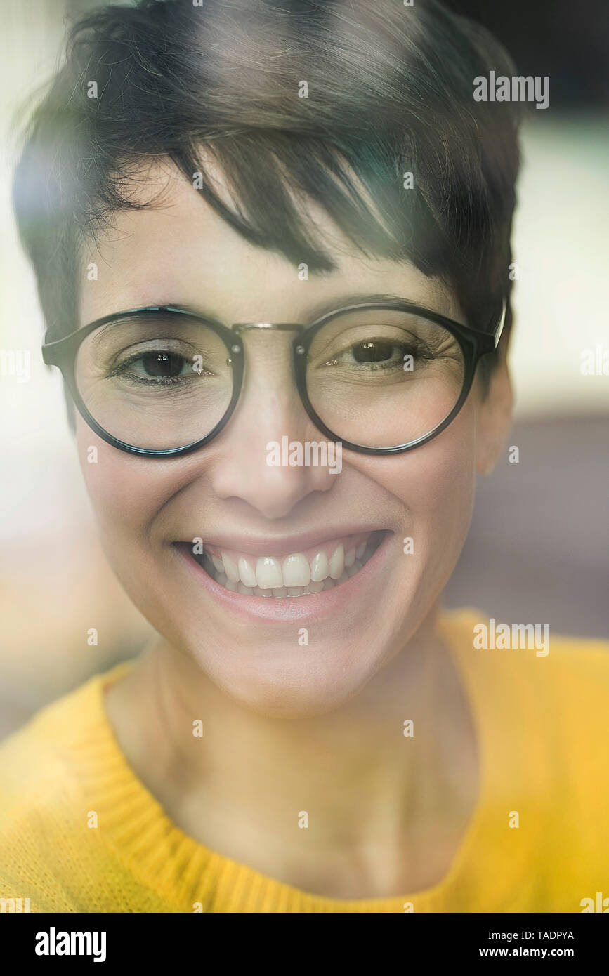 Portrait of laughing woman behind windowpane Stock Photo