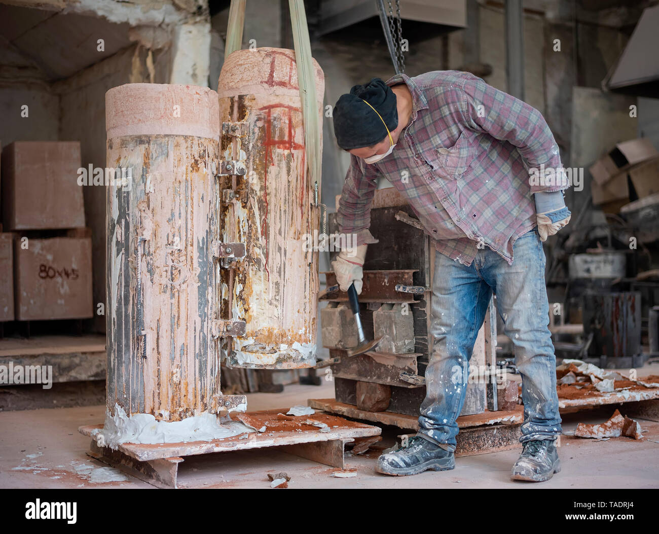 Art foundry, Foundry worker hammering on casting mould Stock Photo