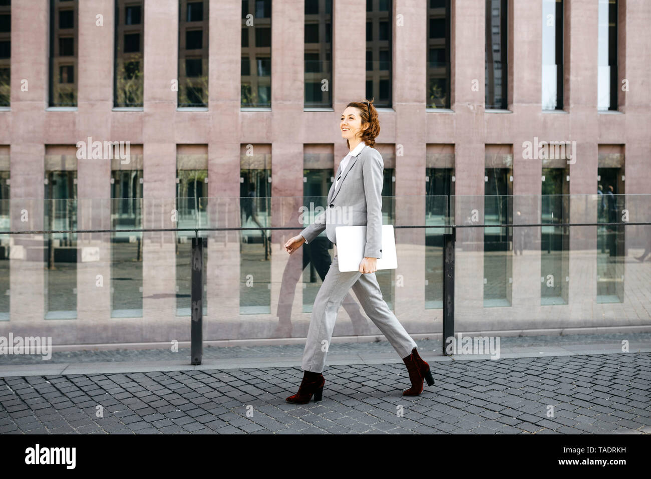Businesswoman with laptop, commuting in the city Stock Photo