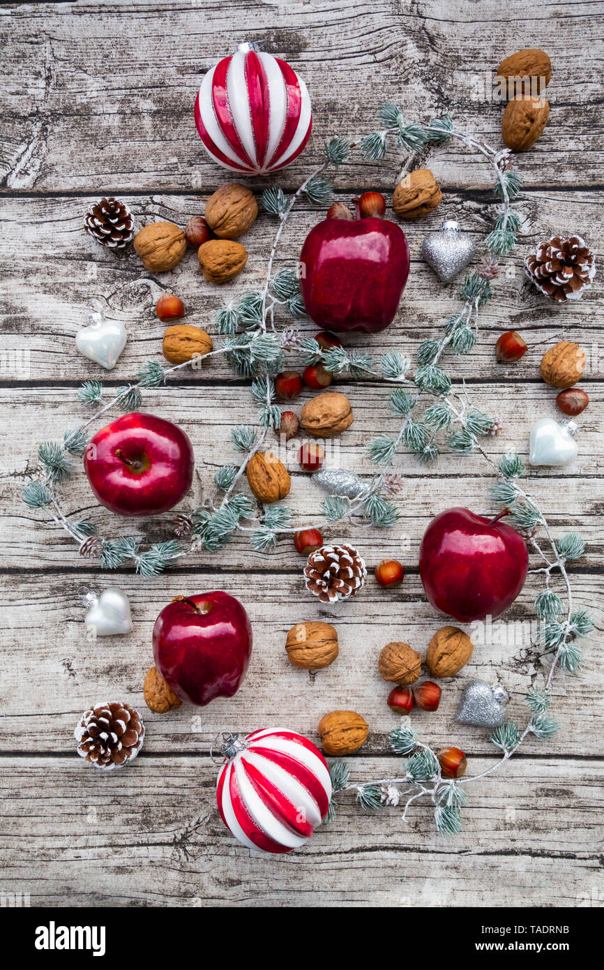 Christmas apples, walnuts, hazelnuts and Christmas decoration on wood Stock Photo