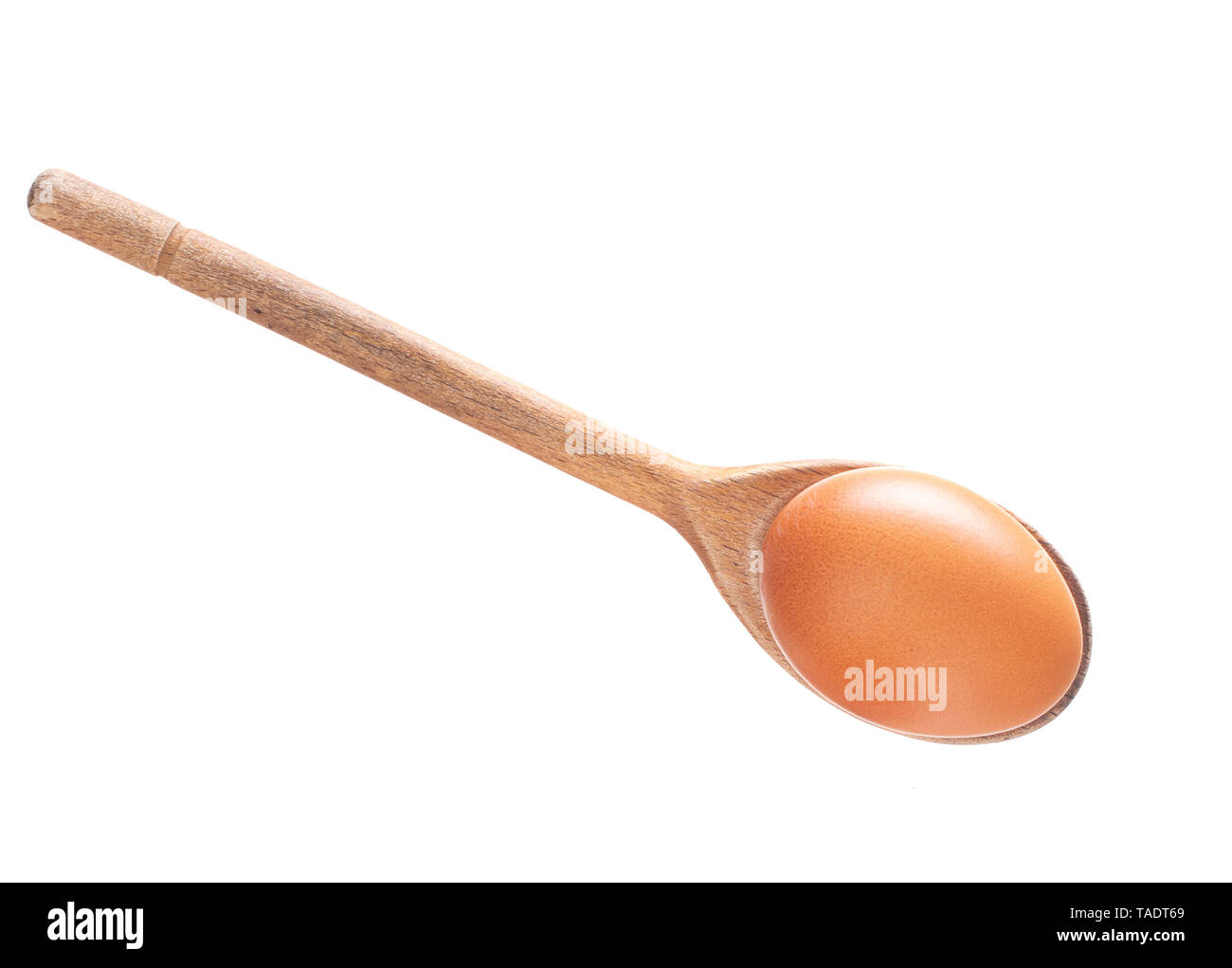 Brown egg on wooden spoon isolated on white. Stock Photo