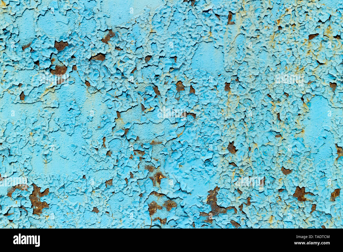 Rusty metal surface painted with peeling blue paint. Stock Photo