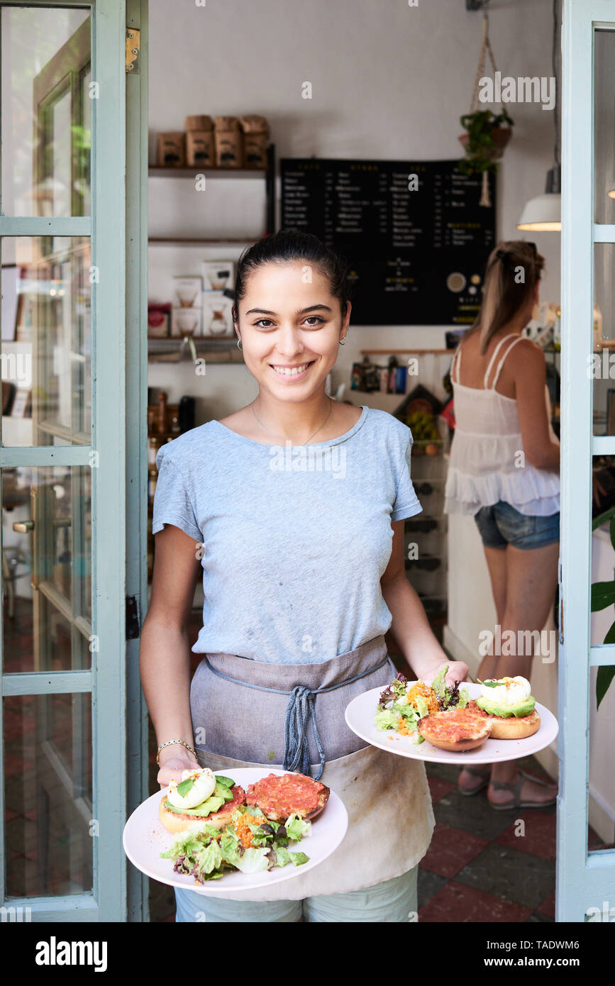Portrait of smiling waitress serving breakfast Stock Photo