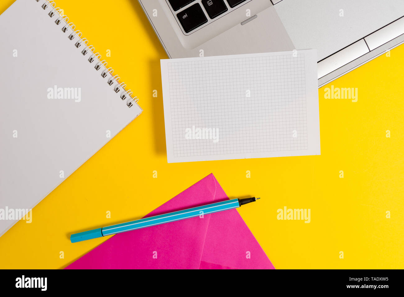 Laptop marker squared sheet spiral notebook envelope colored background