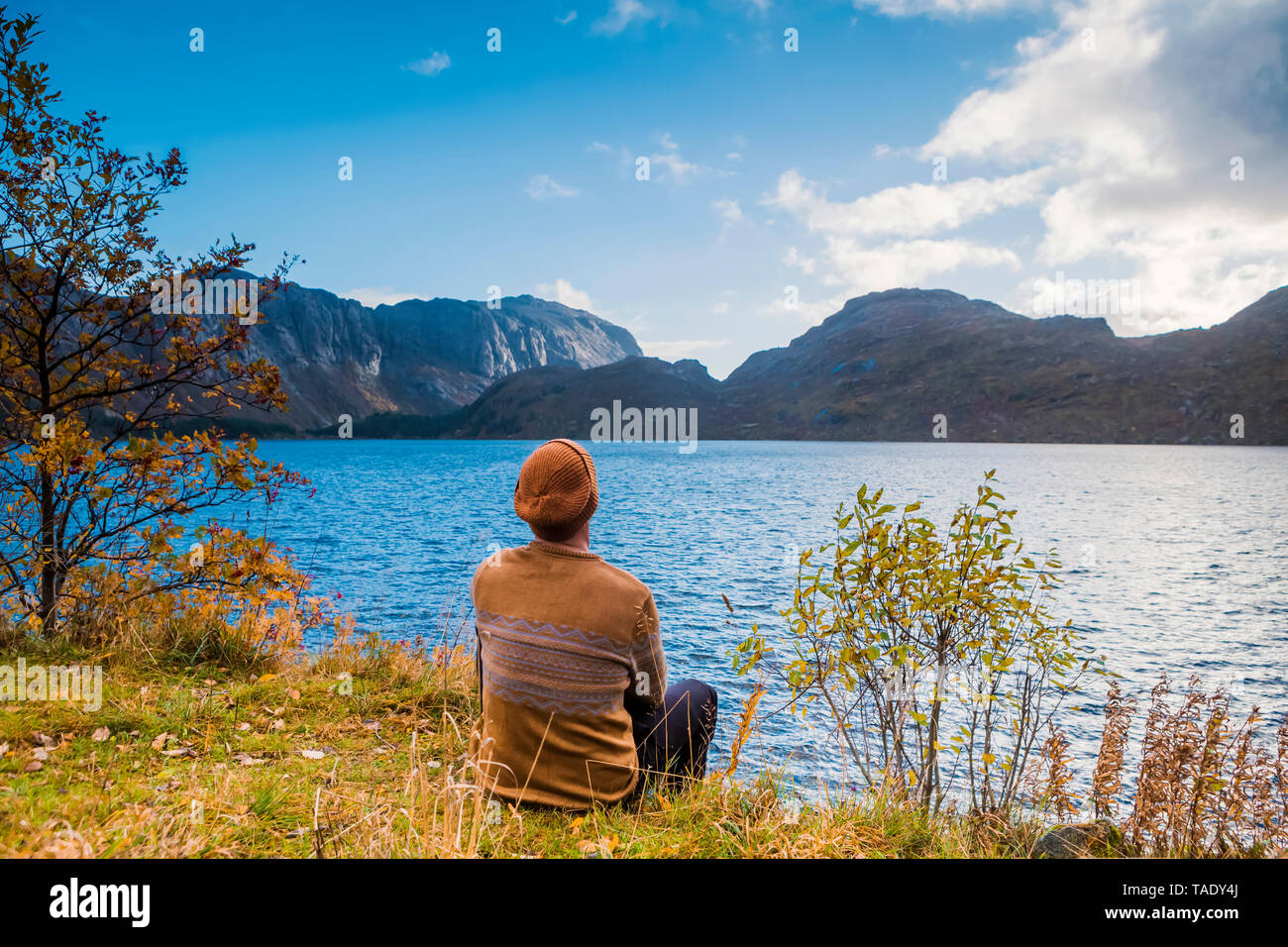Norway, Lofoten Islands, Storvand, man sitting at the seashore Stock Photo