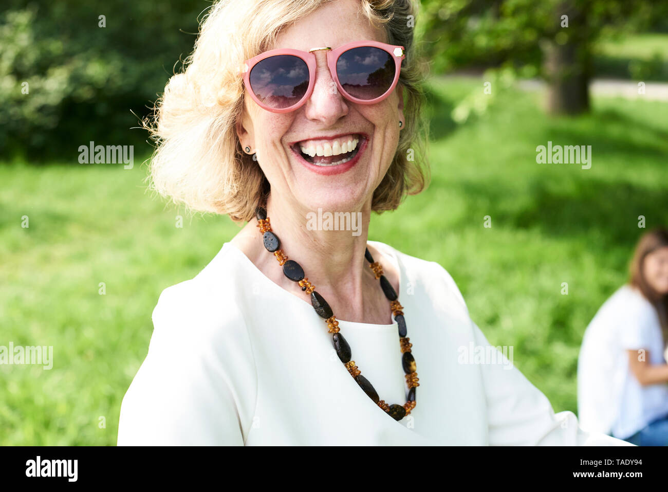 Portrait of happy senior woman wearing sunglasses in park Stock Photo