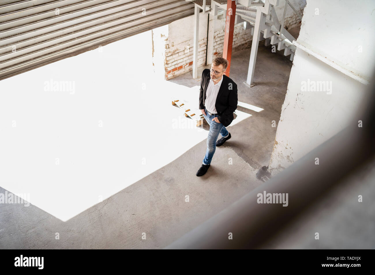 Bird's eye view of businesman walking at loading bay in a factory Stock Photo