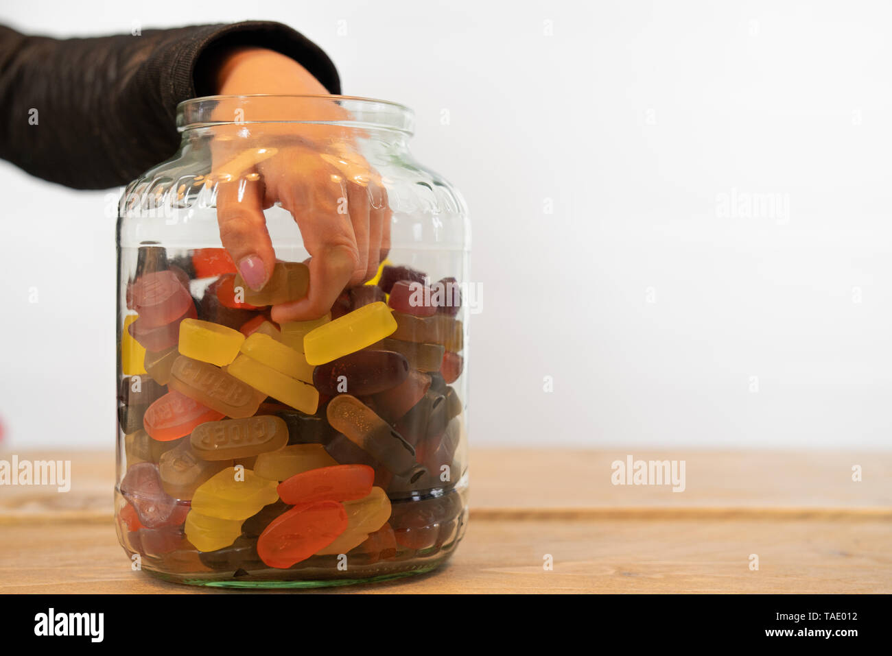 hand of child in candy jar. Grabbing candy out of the jar, white ...