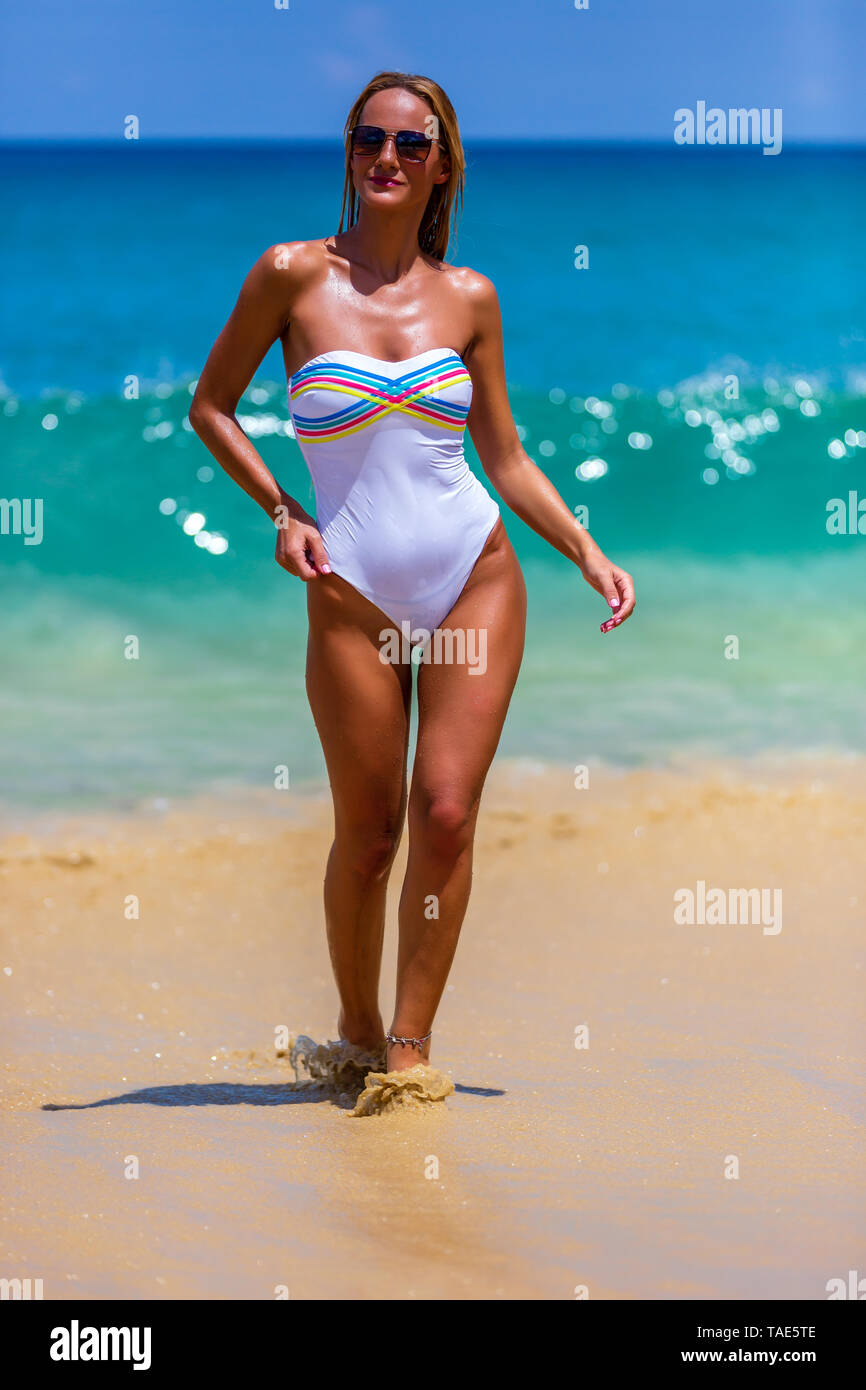 Sexy slim woman in white bikini walking through the water at Karon beach,  Phuket, Thailand Stock Photo - Alamy
