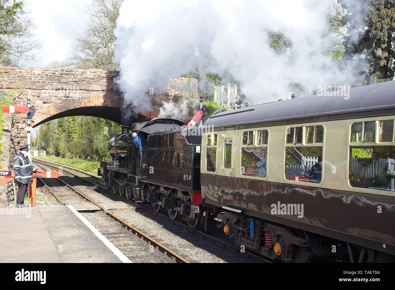 Steam train just leaving the station on a heritage railway line, England, UK. Stock Photo