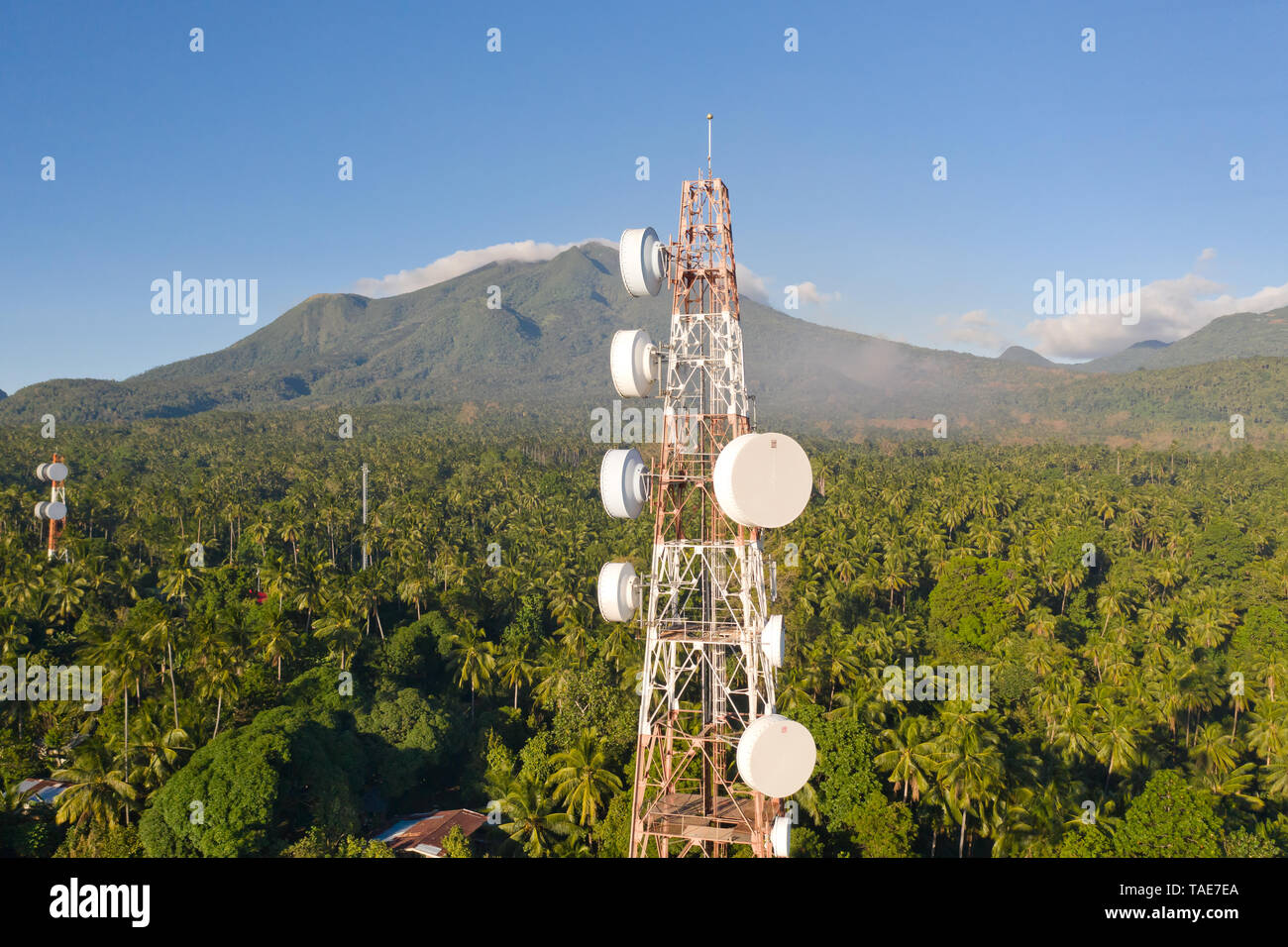 Telecommunication tower, communication antenna on Camiguin Island, Philippines. Repeaters on a metal tower. Landscape with hills and rainforest, view  Stock Photo