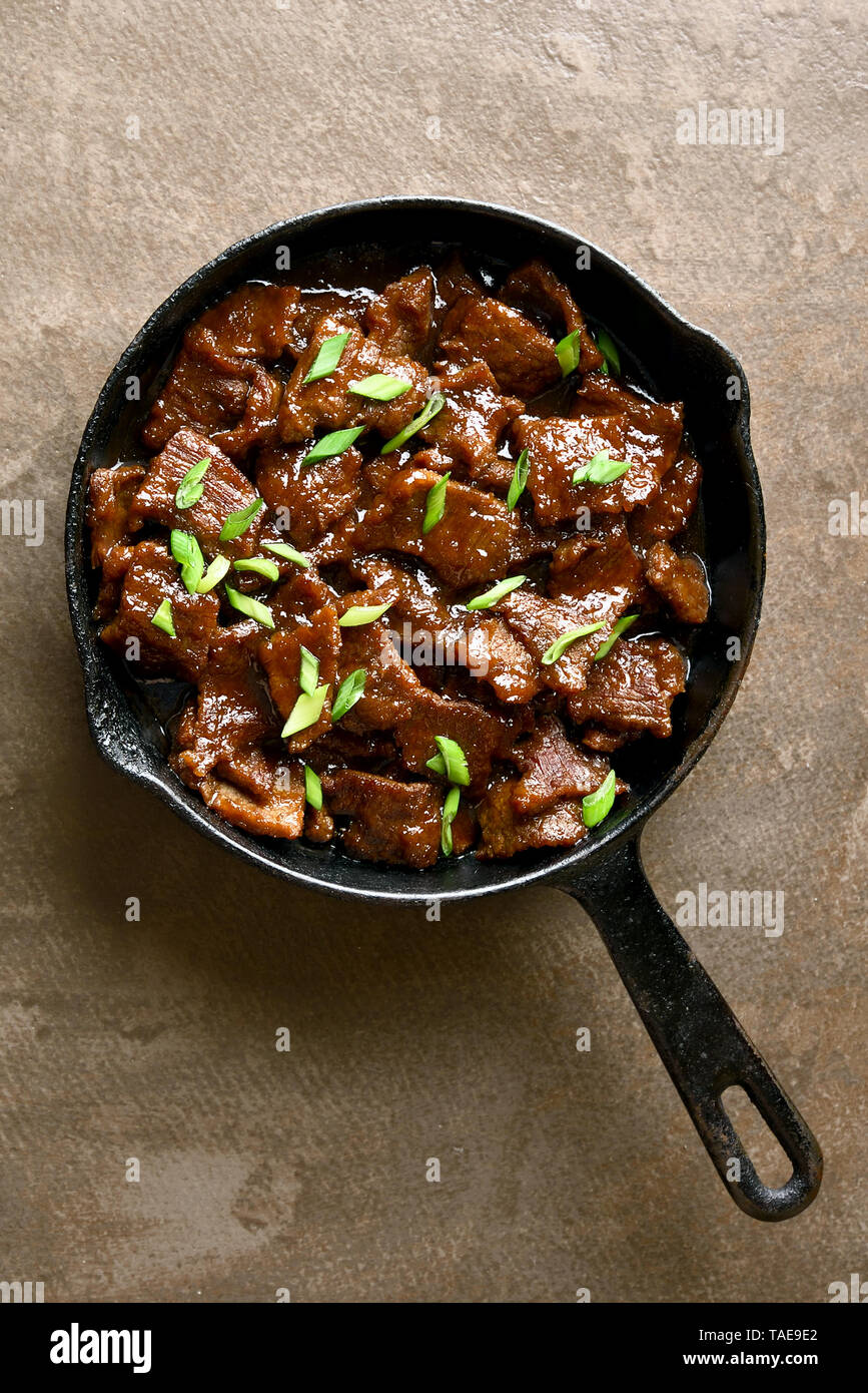 Beef stewed in soy sauce with spices in asian style on brown background