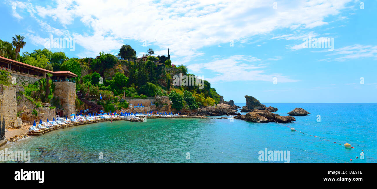 Mermerli Plaji or Mermerli beach with clear azure water in old town Kaleici district of popular seaside resort city Antalya Turkey. Panorama. Stock Photo