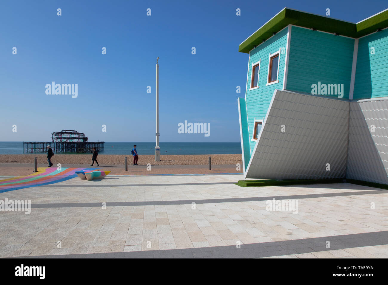 England, East Sussex, Brighton, Upside down house visitor attraction on the seafront opposite the ruins of the West Pier. Stock Photo