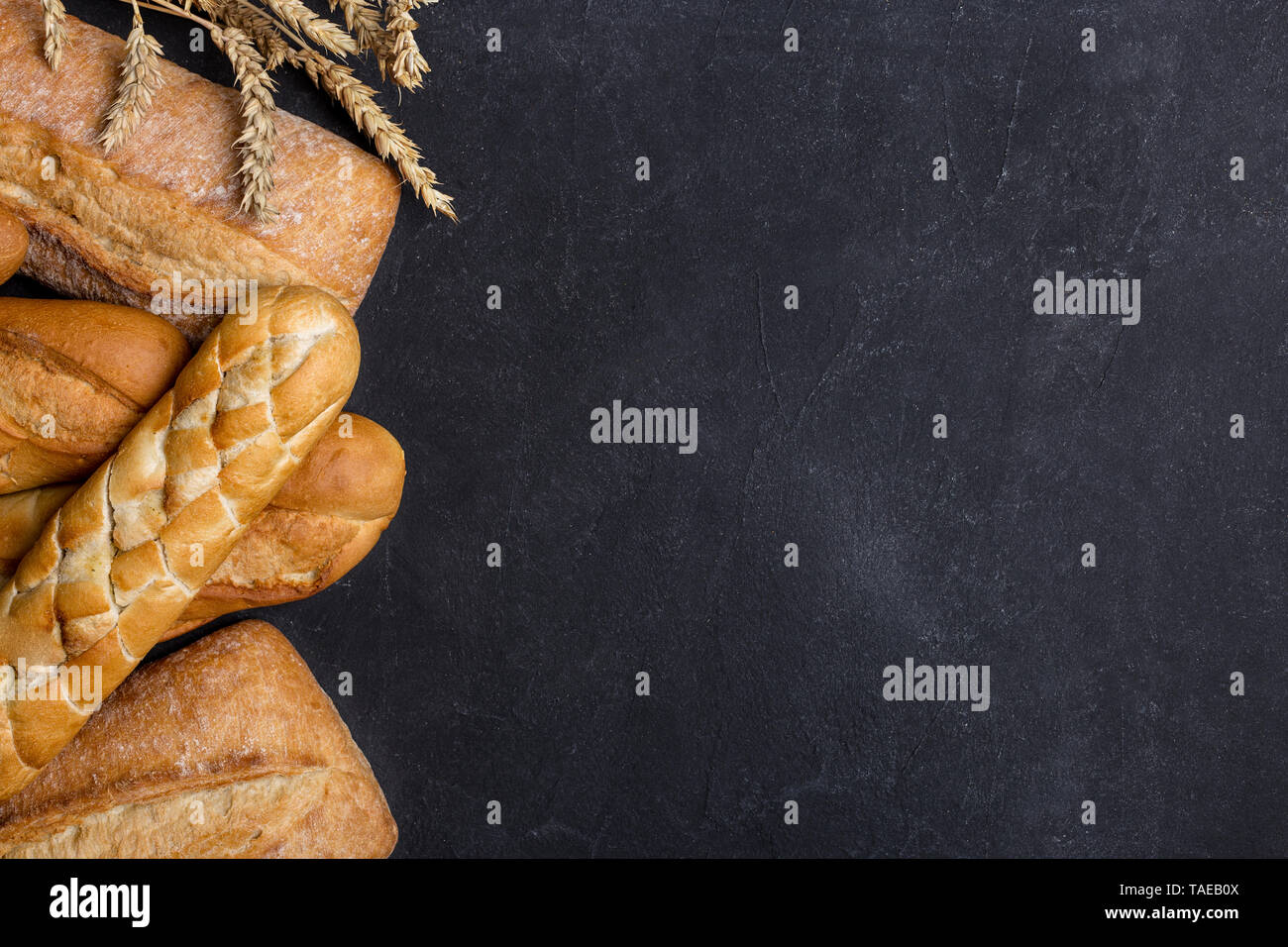 Free space background with different kind of grain bread on dark background. Left edge, top view, flat lay Stock Photo