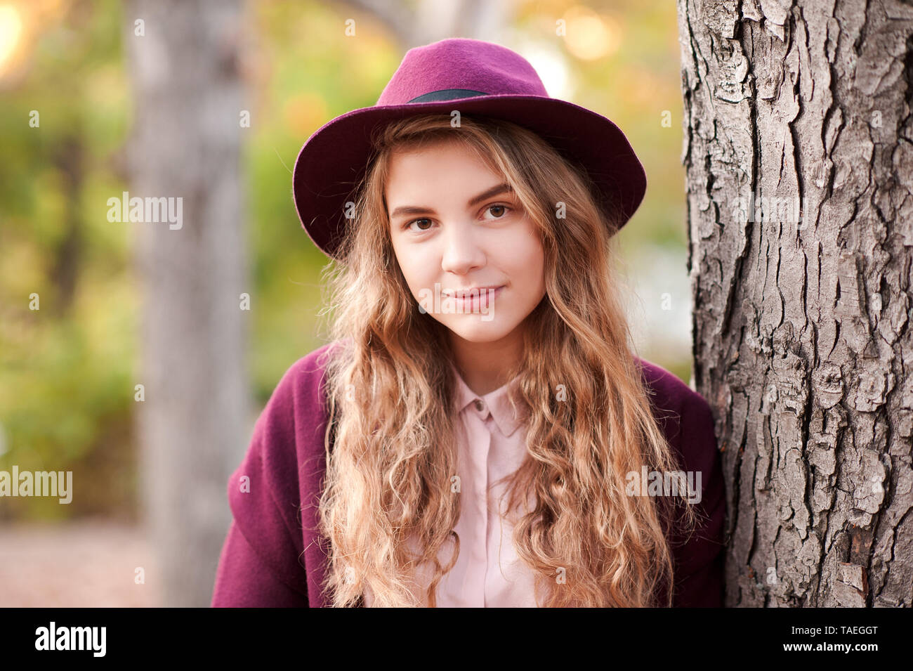 Smiling beautiful girl 14-16 year old wearing winter jacket and hat outdoors. Looking at camera. Childhood. Stock Photo