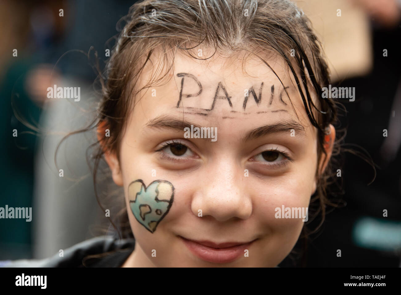 OSLO - MAY 24, 2019: A student wears face paint reading 'Panic' with a heart-shaped earth as thousands march in the School Strike for the Climate in Oslo, Norway, May 24, 2019. Stock Photo