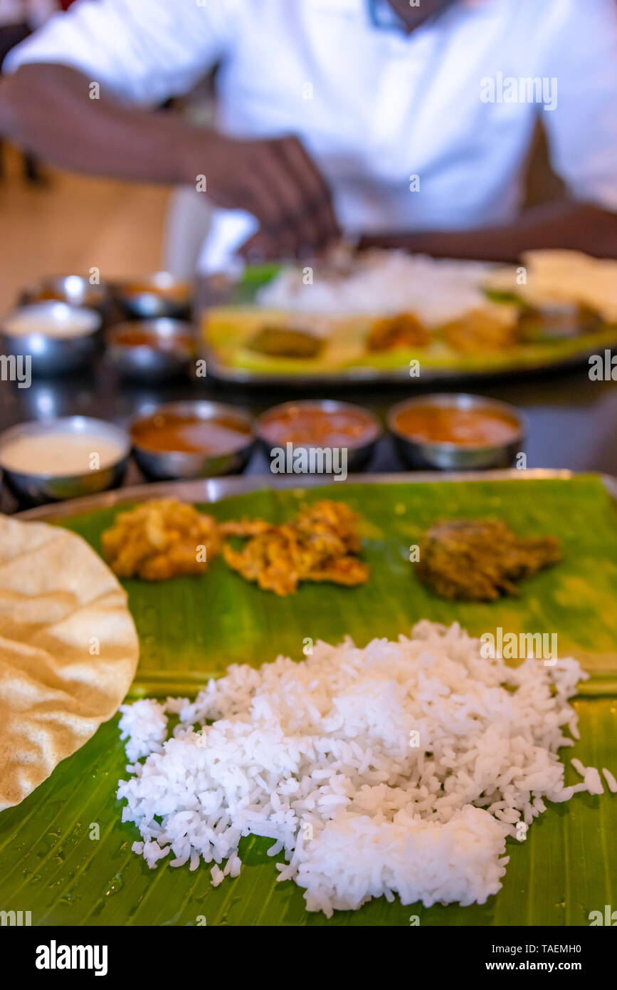 Vertical view of a typical vegetarian thali meal being eaten with hands in India. Stock Photo