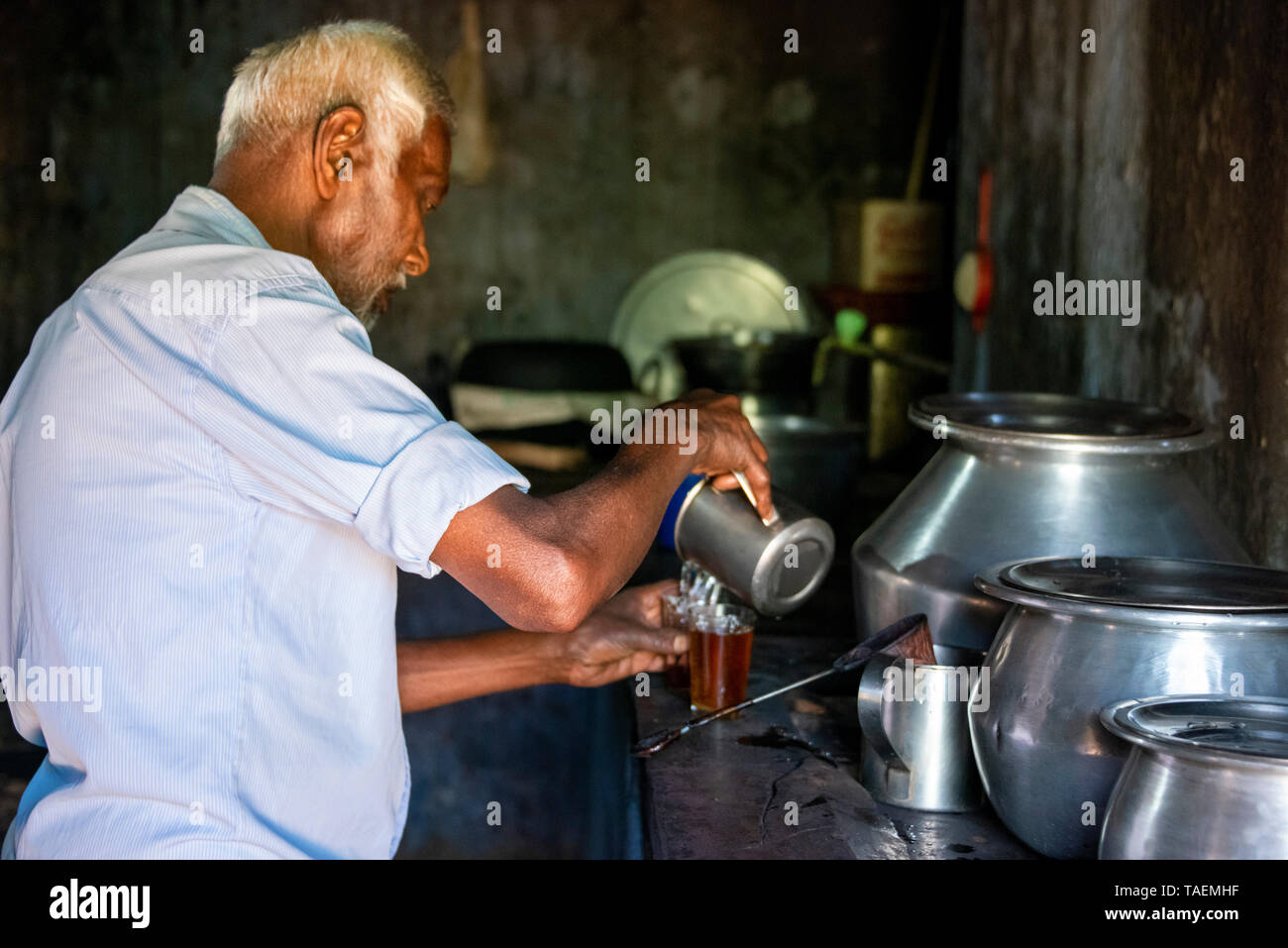 Horizontal portrait of a man making tea in India. Stock Photo