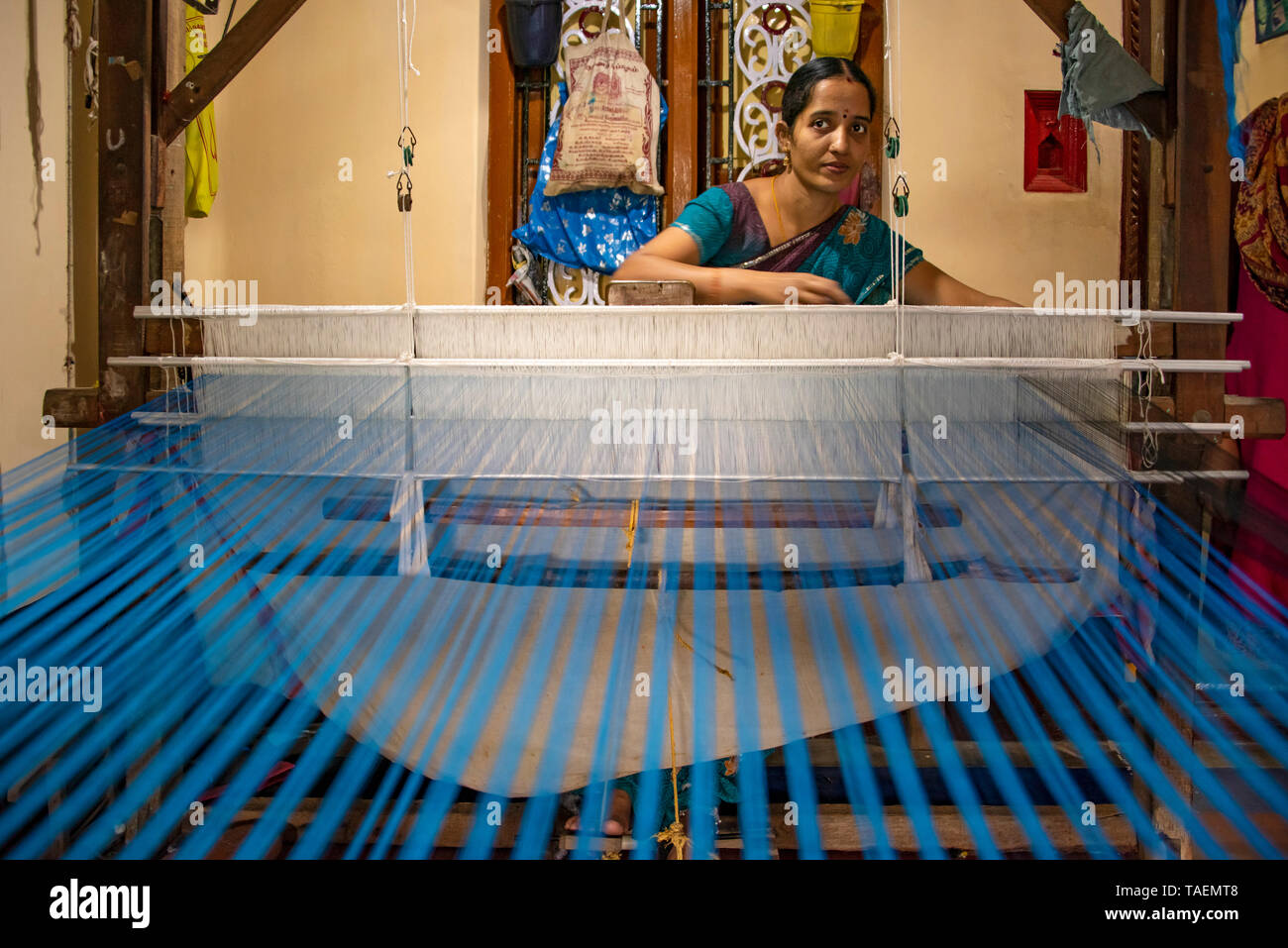 Horizontal portrait of a lady using a floor loom in India. Stock Photo