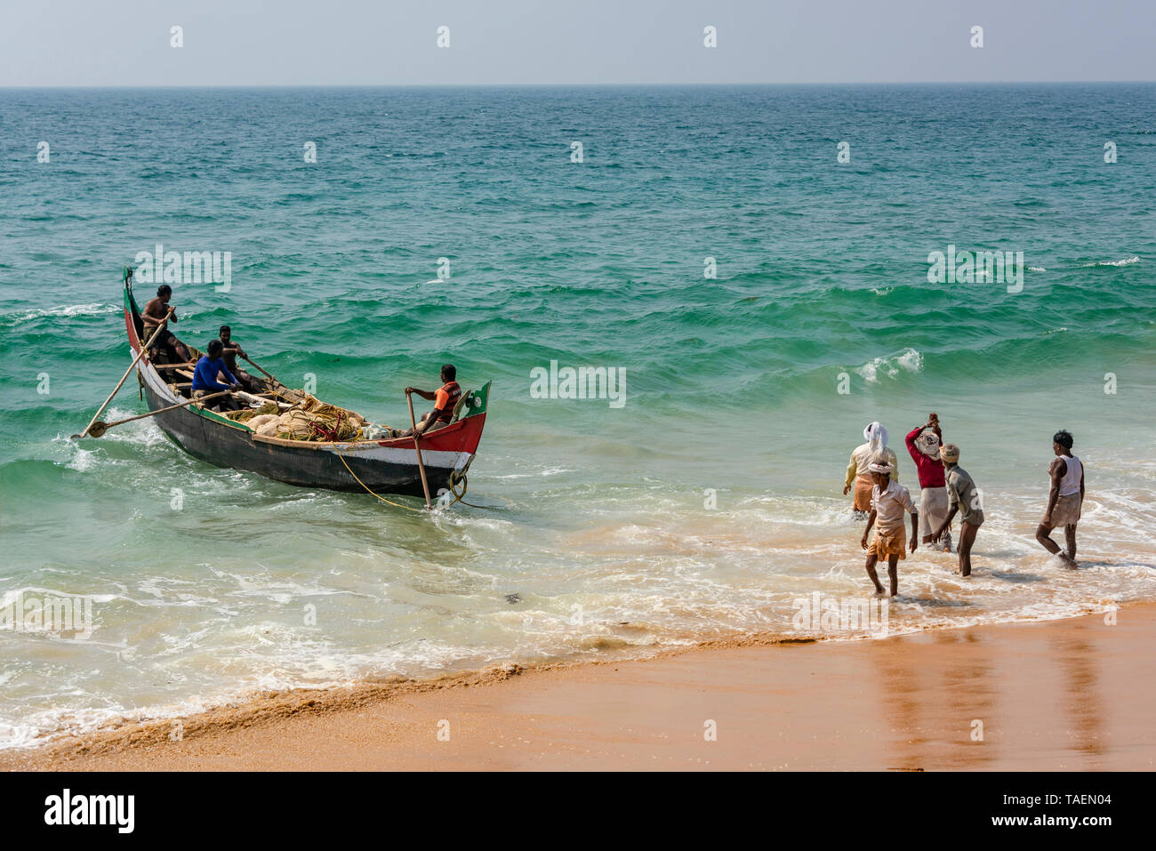 Horizontal view of local fishermen rowing out to sea in Kerala, India. Stock Photo