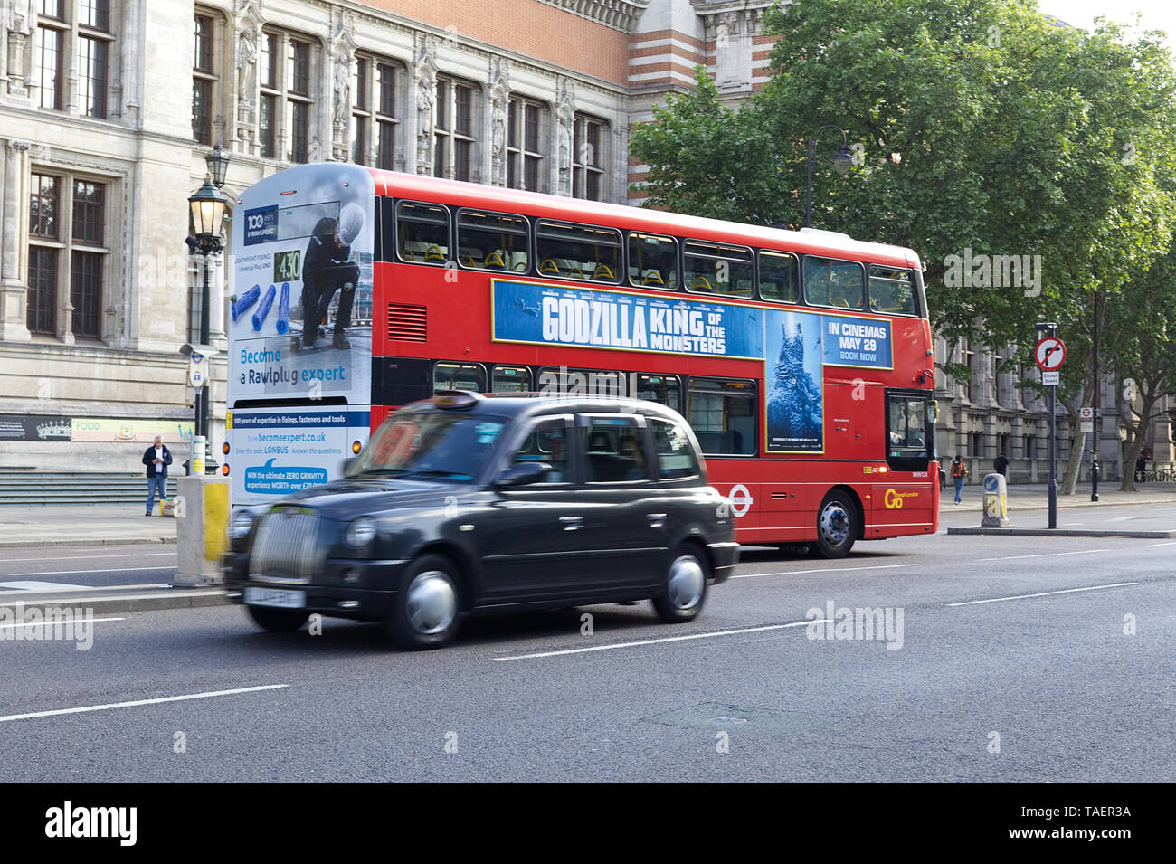 Godzilla King of the monsters Advertised on a London Bus as a black cab passes by Stock Photo