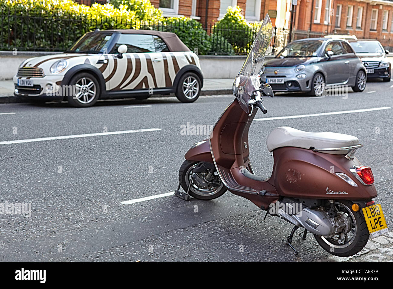 Scooter and a mini Parked in Mayfair, London Stock Photo