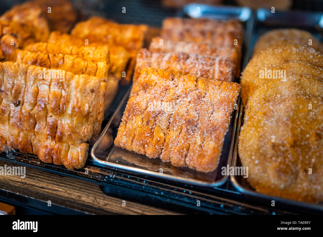 Closeup of many dessert pastries with sugar on shelf tray display