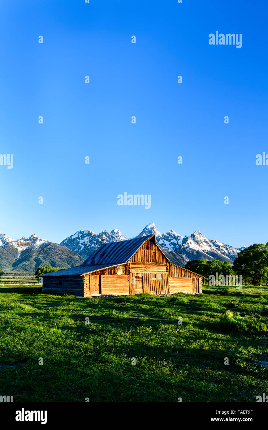 An old barn along Mormon Row with the Grand Tetons in the background near Jackson Hole, Wyoming USA. Stock Photo