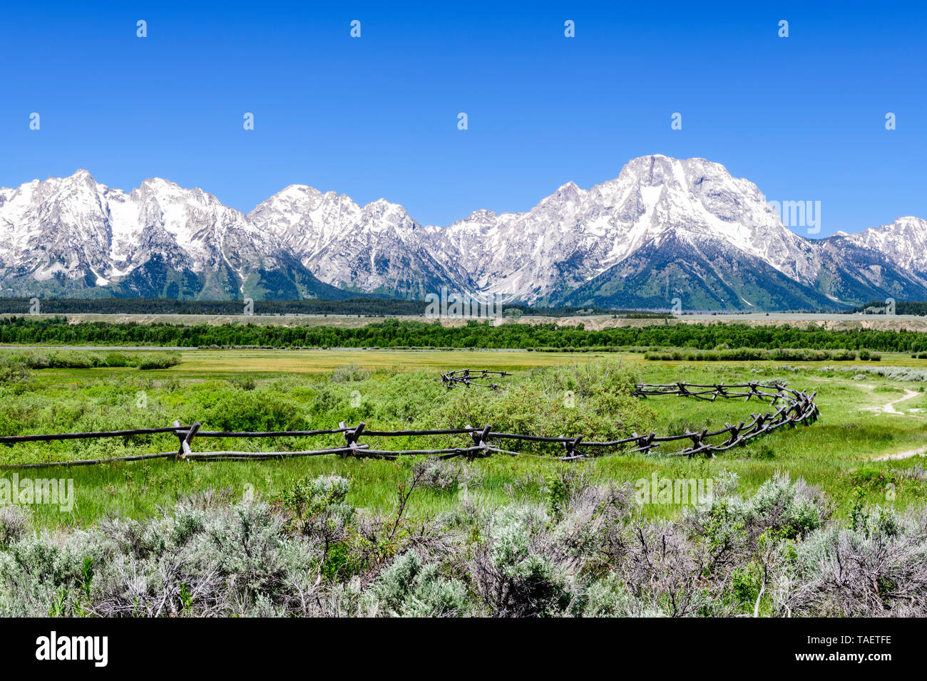 A fence with the Grand Tetons in the background in Grand Teton National Park near Jackson Hole, Wyoming USA. Stock Photo