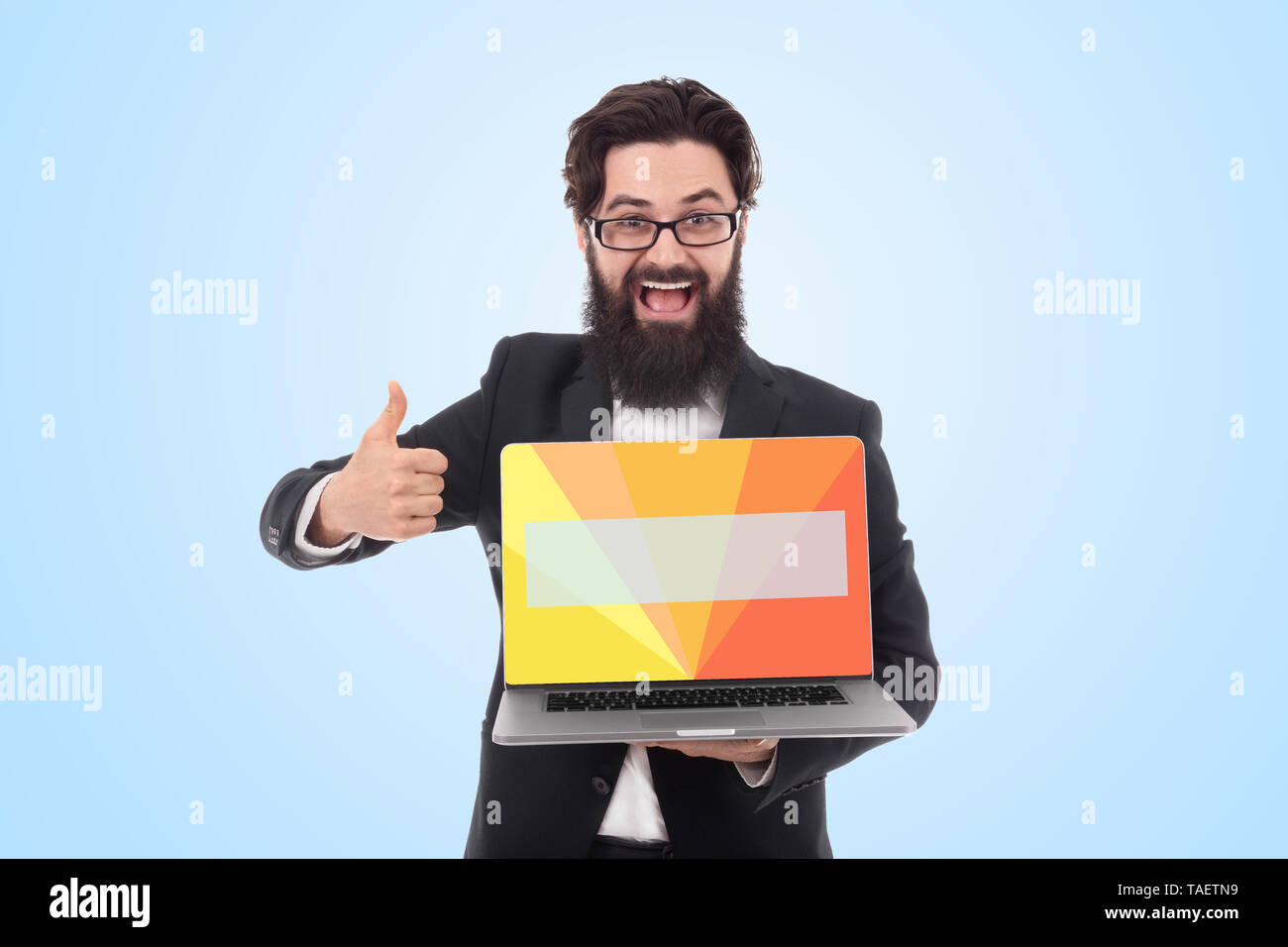 cheerful bearded businessman holding digital laptop with colorful screen for advertising and showing thumb up over blue background Stock Photo