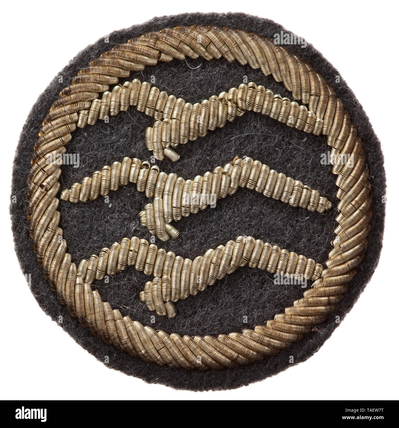 A glider pilot's badge 'C' certificate in officer quality cloth issue Drei silberne, handgestickte Schwingen im Kranz auf grauem Wollfilz-Grund. Trage- und Altersspuren. Durchmesser ca. 30 mm. historic, historical, Air Force, branch of service, branches of service, armed service, armed services, military, militaria, air forces, object, objects, stills, clipping, clippings, cut out, cut-out, cut-outs, 20th century, Editorial-Use-Only Stock Photo