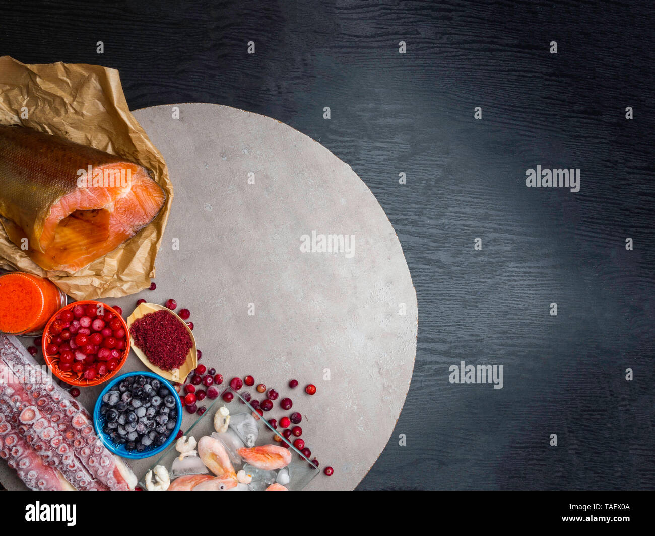 astaxanthin rich food as shrimps in ice, red fish salmon, blueberry