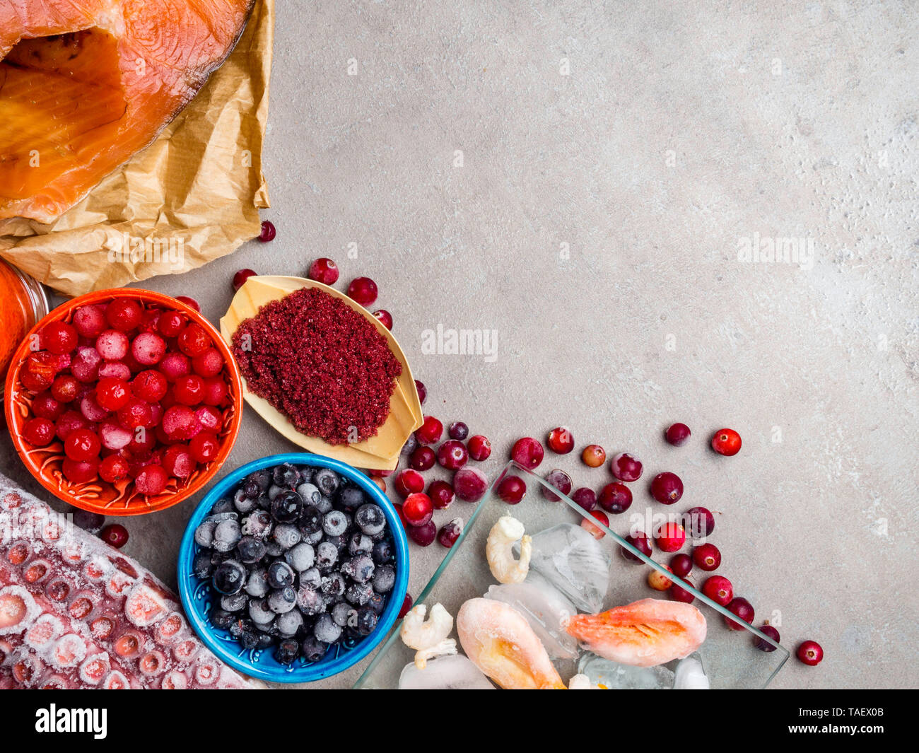 astaxanthin rich food as shrimps in ice, red fish salmon, blueberry