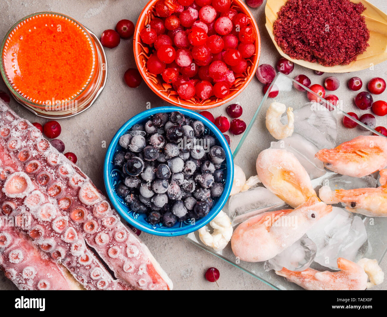 astaxanthin rich food as shrimps in ice, red fish salmon, blueberry