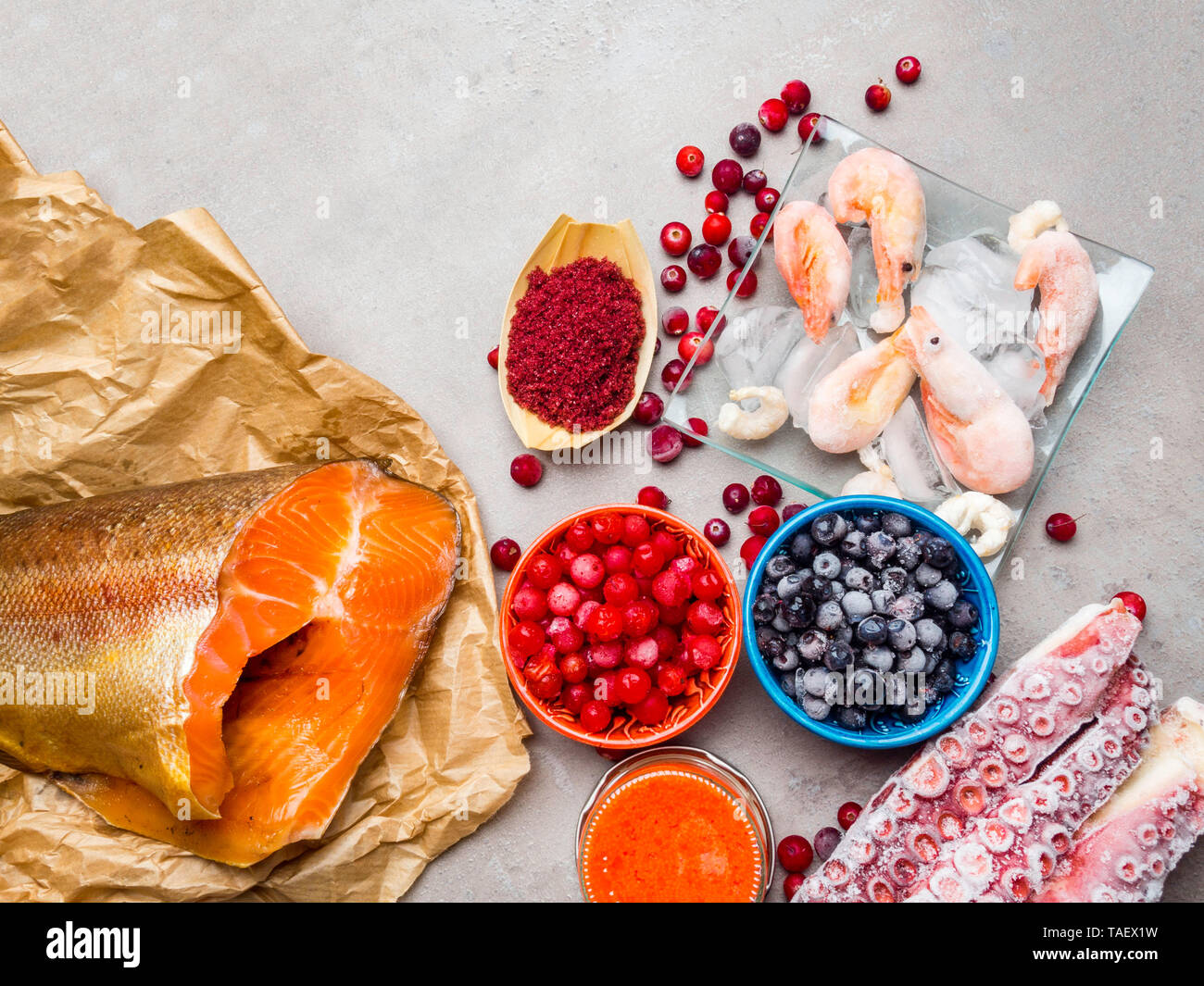 astaxanthin rich food as shrimps in ice, red fish salmon, blueberry