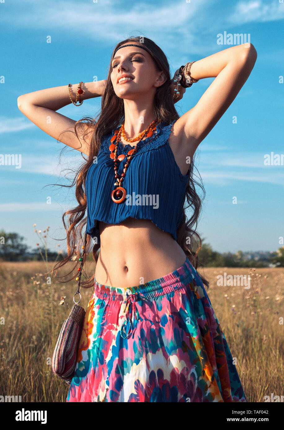 Outdoor portrait of the smiling cute young boho (hippie) girl in