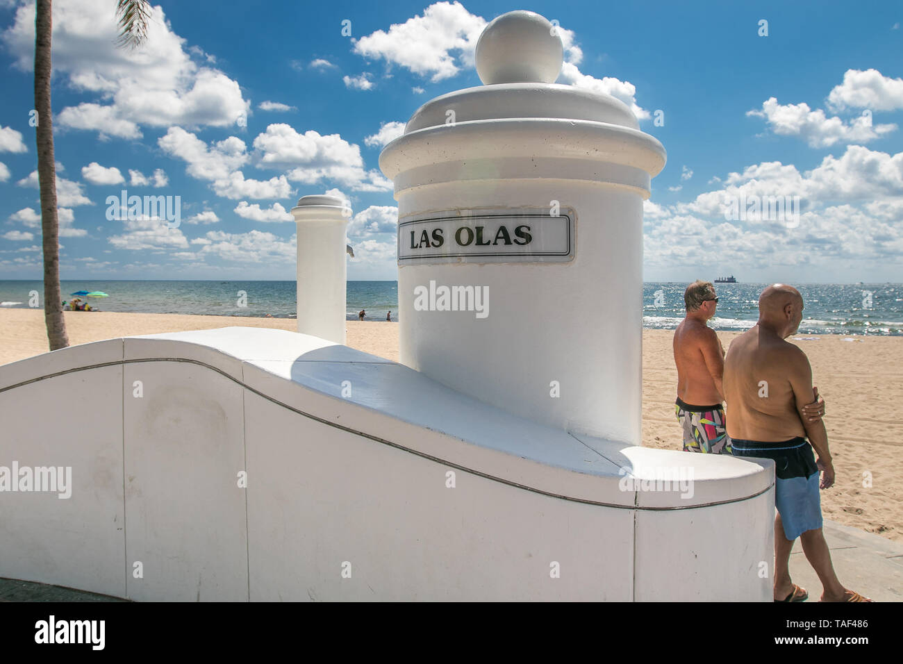 Fort Lauderdale, FL, 5/15/2019: Two men are conversing while standing on the beach across Las Olas Boulevard. Stock Photo
