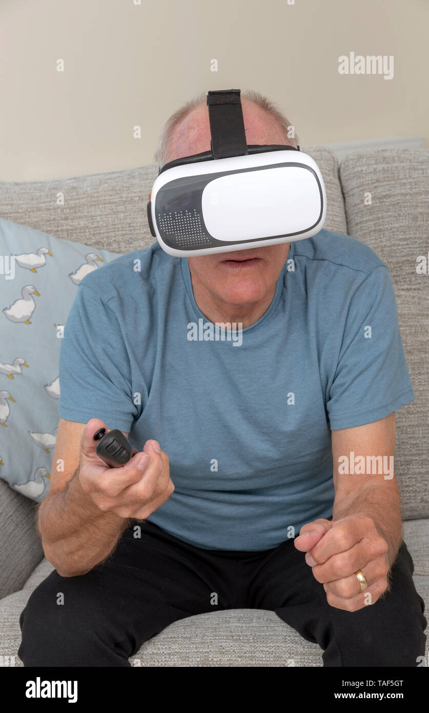 Portsmouth UK, May 2019. Elderly man having fun and frights wearing a pair of virtual reality goggles Stock Photo