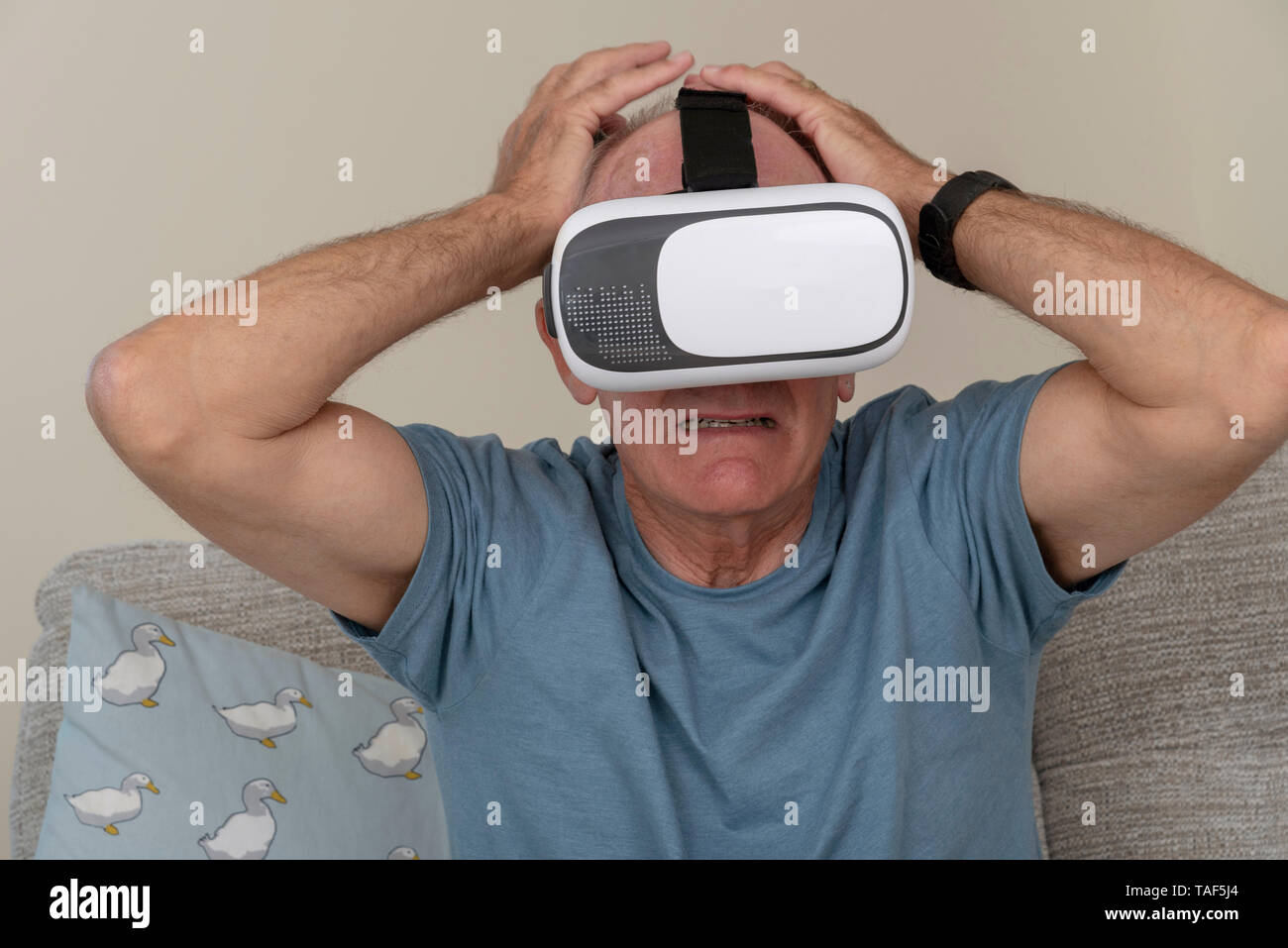 Portsmouth UK, May 2019. Elderly man having fun and frights wearing a pair of virtual reality goggles Stock Photo