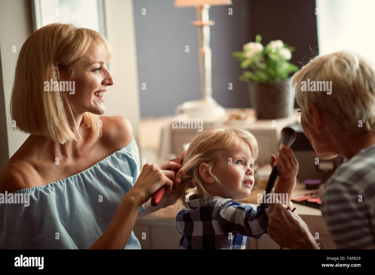 Cute girl with mother and grandma beautifies and having fun Stock Photo ...