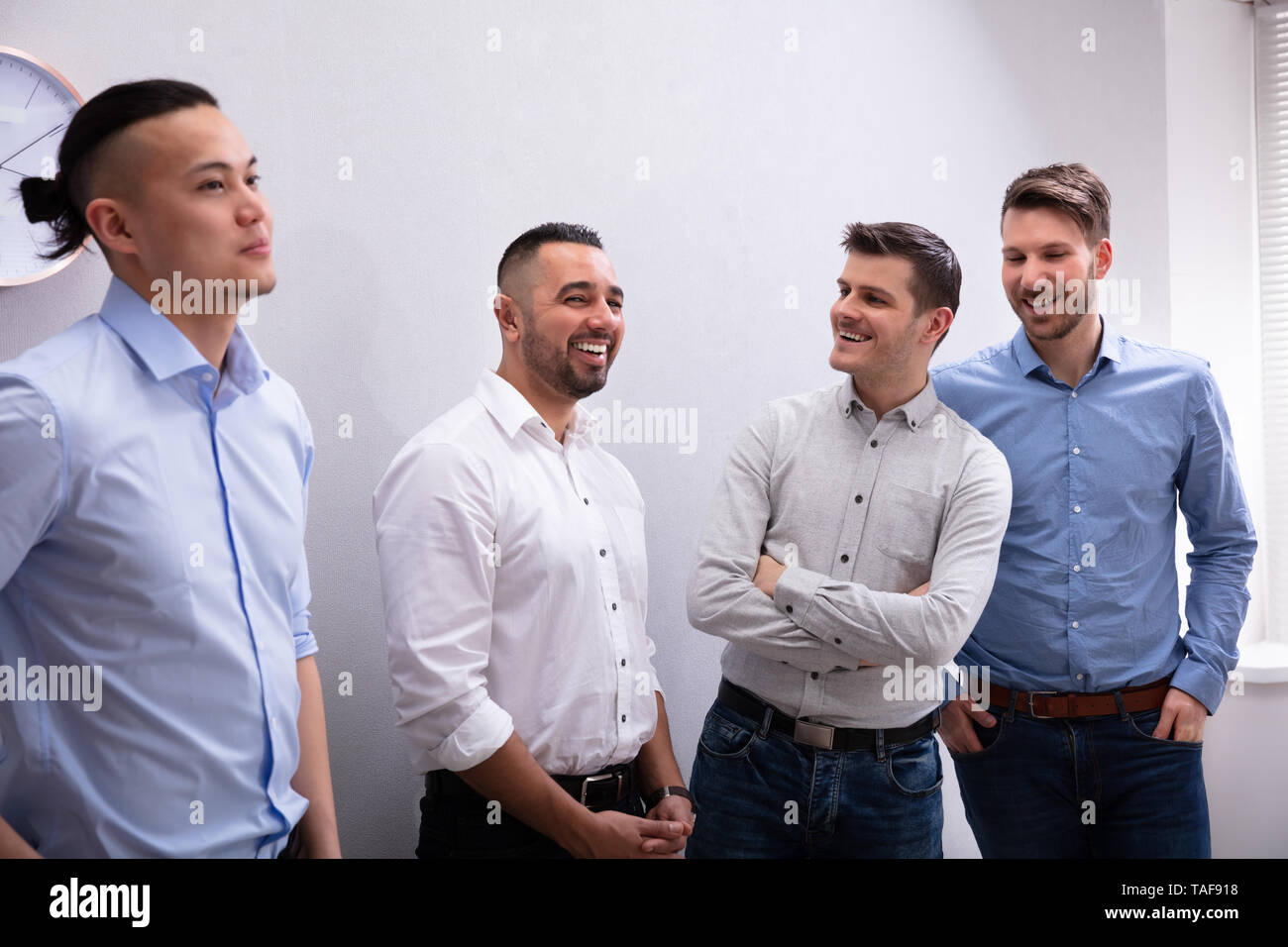 Diverse Group Of Smiling Businessmen Talking Together Stock Photo