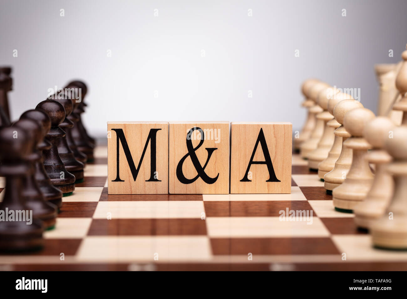 Chessboard With Wooden Blocks Showing Mergers And Acquisitions Concept Stock Photo